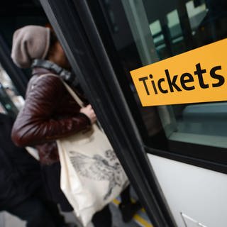 Ein Aufkleber mit der Aufschrift "Tickets" ist an einem Bus angebracht. 