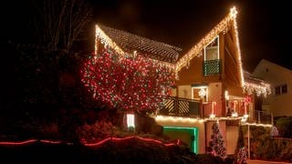 Zu Weihnachten ist ein Haus mit vielen Lichterketten geschmückt