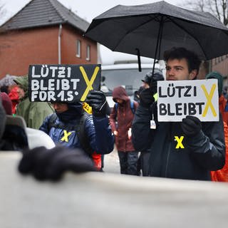 "Lützi bleibt" ist auf den Schildern zu lesen, die von Demonstranten getragen werden.