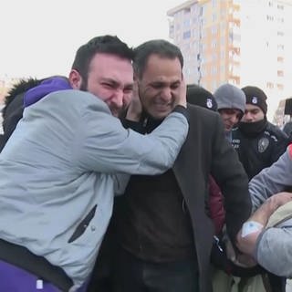 Zwei weinende Männer umarmen sich in der Türkei nach Erdbeben
