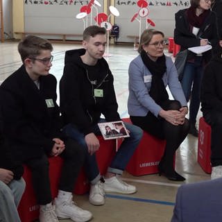 Bildungsministerin Stefanie Hubig mit Jugendlichen bei Vortrag