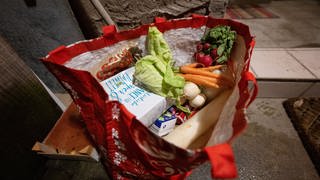 Eine Tasche voller Lebensmittel, die aus Abfalleimern eines Supermarktes stammen.