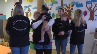 Erzieherinnen und Kinder der Kita Schloß Wichtelmann in Otterbach stellen T-Shirts "Kita Paten gesucht" vor