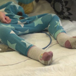 ein Kind liegt auf einem Krankenhausbett