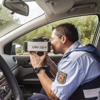 Polizist im Auto mit Radarfalle