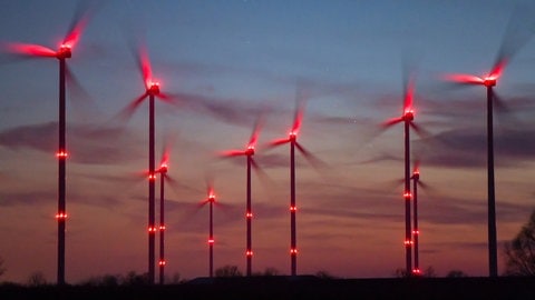 Auf den windstarken Hunsrückhöhen drehen sich viele Windräder im Wald.