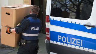 Ein Polizeibeamter entlädt am Landeskriminalamt Rheinland-Pfalz einen Transporter mit sichergestelltem Material aus einer Razzia in mehreren Bundesländern gegen die italienischen Mafia 'Ndrangheta. 