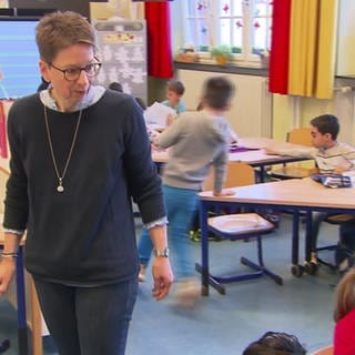 Lehrerin betreut Kinder im Klassenzimmer