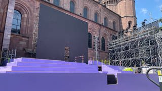 Vor dem Wormser Dom steht eine riesige lila Bühne