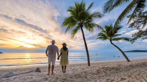 Pärchen am Strand schaut in den Sonnenuntergang