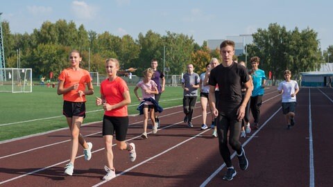 Jugendliche rennen auf dem Sportplatz