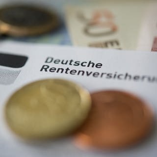 Münzen liegen auf einer Renteninformation der Deutschen Rentenversicherung.
