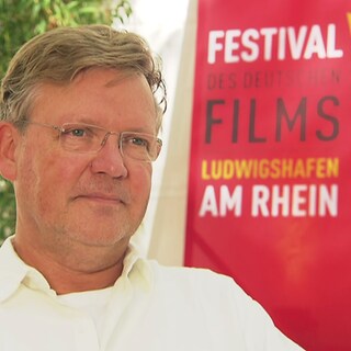 Justus von Dohnányi vor dem Plakat "Filmfestival Ludwisghafen"