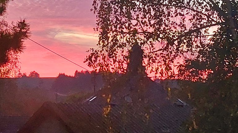 Der Himmel über Schweinschied mit der Kirche im Hintergrund.