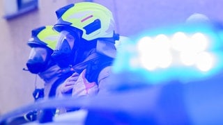 Zwei Feuerwehrmänner tragen Gasmasken zum Schutz vor starker Rauchentwicklung. 