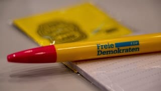 Ein FDP-Stift liegt auf einem Schreibblock.