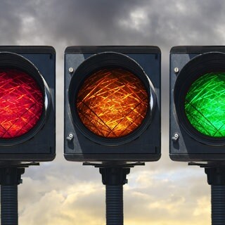 Eine Ampel mit Lichtern in Grün, Gelb und Rot.