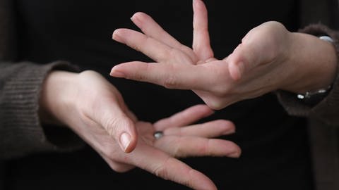 Hände zeigen das Wort "beraten" in Gebärdensprache 