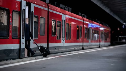 Ein Mann mit Rollkoffer steigt in einen Zug der Deutschen Bahn ein. Die Lokführergewerkschaft GDL hat ihre Mitglieder zum Streik bei der Deutschen Bahn aufgerufen.