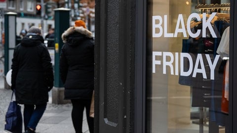 Passanten  und Schaufenster mit Aufschrift "Black-Friday"