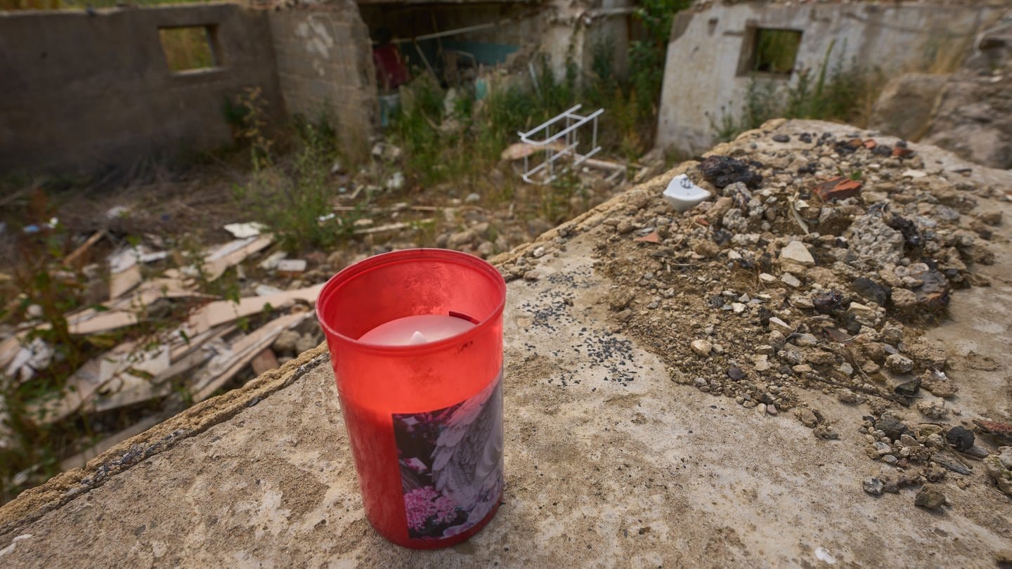 Eine Kerze auf den Grundmauern eines zerstörten Hauses erinnert an Todesopfer der Flutkatastrophe an der Ahr.
