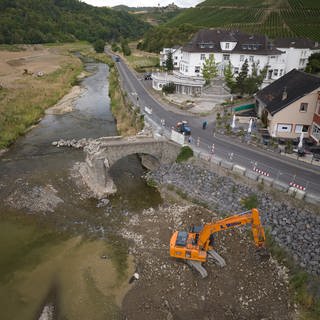 Bagger reißen die 300 Jahre alte Nepomukbrücke in Rech im Ahrtal ab, die vor zwei Jahren durch die Flutkatastrophe schwer beschädigt wurde.