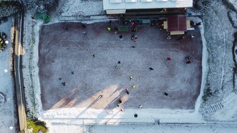 Bei der natürlichen Eisbahn in Meisenheim können Menschen auf einem vereisten Tennisplatz Schlittschuhlaufen.