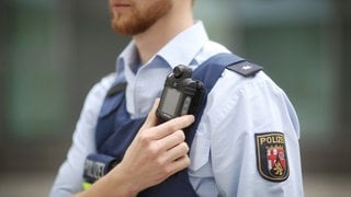 Ein Polizist trägt in Rheinland-Pfalz eine mobile Miniatur-Videokamera an einem Gurt unterhalb seiner Schulter, eine so genannte Bodycam.