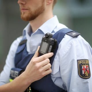 Ein Polizist trägt in Rheinland-Pfalz eine mobile Miniatur-Videokamera an einem Gurt unterhalb seiner Schulter, eine so genannte Bodycam.