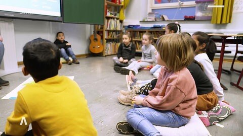 Kinder sitzen im Kreis in der Schule