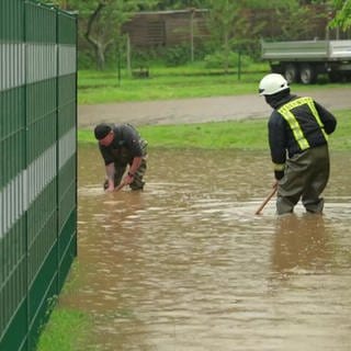 Feuerwehrmänner stehen im Hochwasser