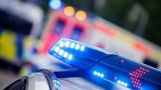 Ein Polizeiauto steht vor einem Krankenwagen.