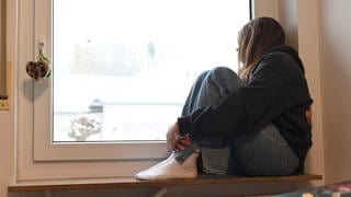 Deprimiert sitzt ein jugendliches Mädchen in ihrem Zimmer. Immer mehr Mädchen unter 14 Jahren melden sich beim Mainzer Frauennotruf.