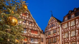 Weihnachtsmarkt in der Moselstadt Bernkastel-Kues mit Weihnachtsbaum und Fachwerkhäusern