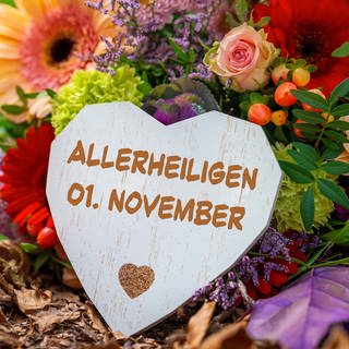 Grab mit Blumenschmuck und Grableuchte, Herz mit Aufschrift Allerheiligen, 1. November   