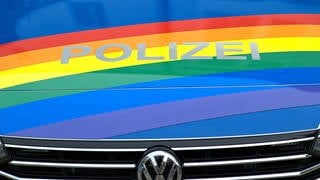 Farben der queeren Bewegung über VW-Front-Polizeiautos  