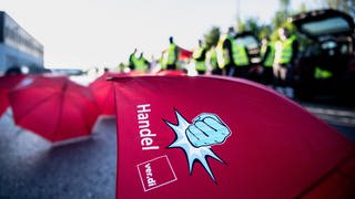 Rote Regenschirme mit dem Aufdruck "Handel. Verdi" In Rheinland-Pfalz organisiert die Gewerkschaft Verdi erste Warnstreiks im Versand- und Einzelhandel.