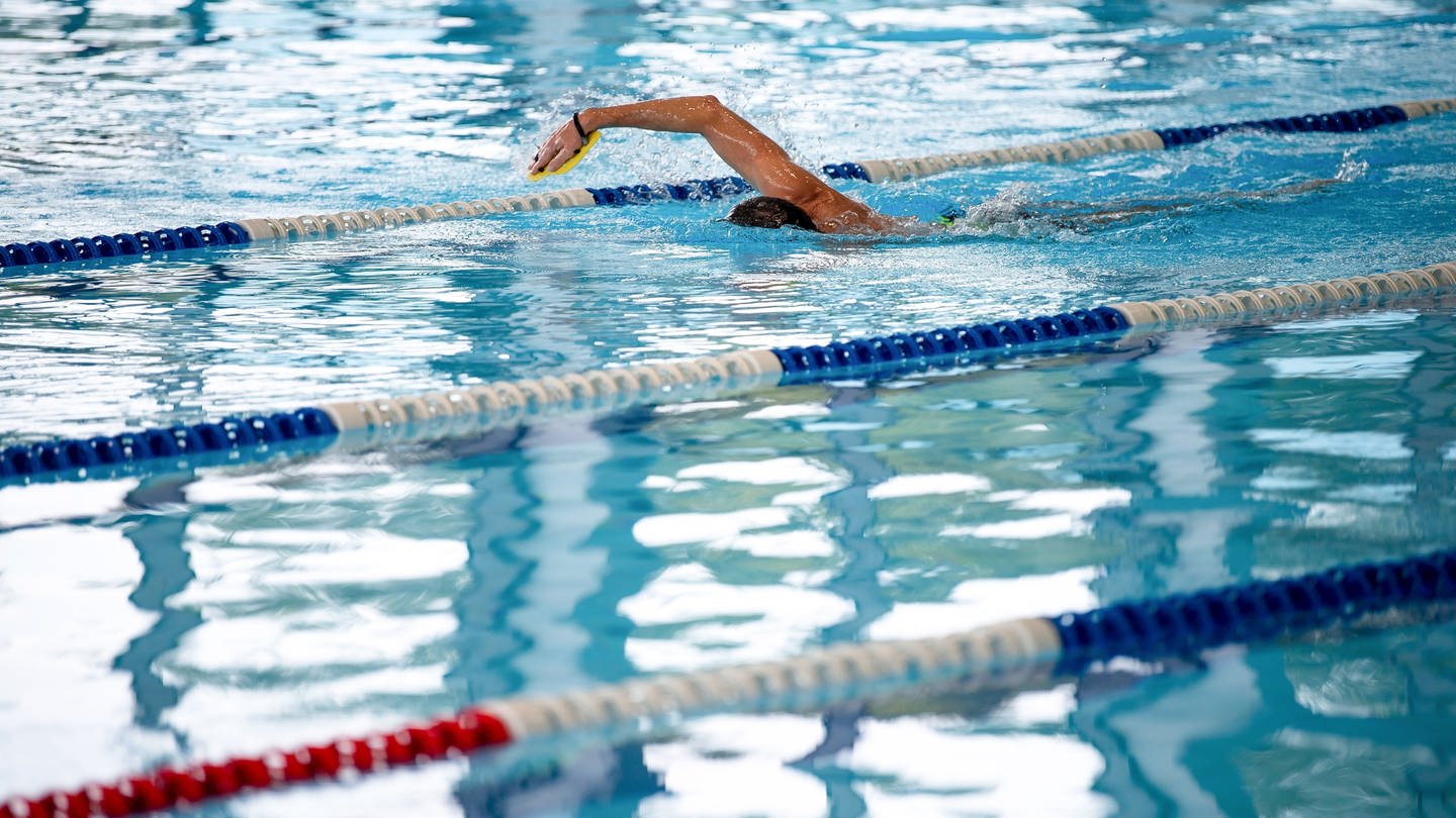 Ein Schwimmer im Hallenbad. In RLP erhöhen erste Bäder nach der Energiekrise wieder die Wassertemperatur.