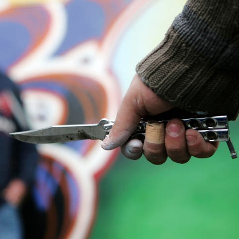 Eine Person führt sein Springmesser vor (nachgestellte Szene)
