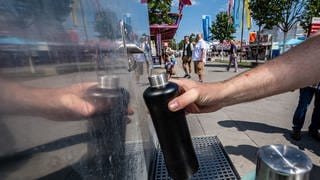 Ein Besucher befüllt sich seine Flasche an einem Trinkwasserbrunnen. Mit solchen und weiteren Maßnahmen wollen sich Städte gegen den Klimawandel rüsten.