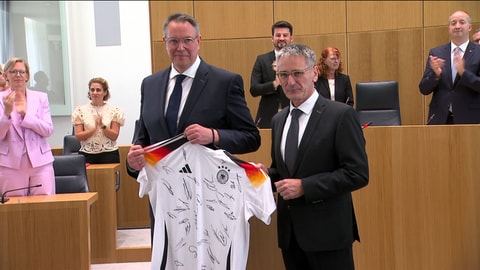 Der neue Ministerpräsident Alexander Schweitzer mit einem Trikot der DFB-Elf.