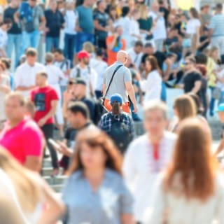 Eine bunte Menschenmenge auf einem Platz im Sommer