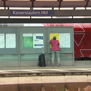 Mann Steht vor Fahrplan am bahnhof Kaiserslautern
