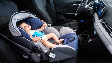 Eine Puppe sitzt für Testzwecke in einem Kindersitz eines Autos, in dem ein KI-System und Sensoren des Unternehmens Marquardt verbaut sind. Ziel ist es, den Hitzetod von Kindern in Fahrzeugen zu verhindern.