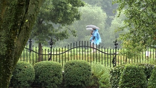 Zwei Spaziergänger mit Regenschirm im Park von Schloss Lieser