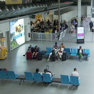 Reisende im Wartebereich des Frankfurter Flughafens. Es sind Sommerferien - noch drei Wochen. 