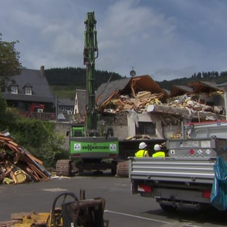 In Kröv an der Mosel haben am Freitag die Abrissarbeiten am eingestürzten Hotel begonnen. Möglicherweise soll die Leiche des Verschütteten bald geborgen werden. 