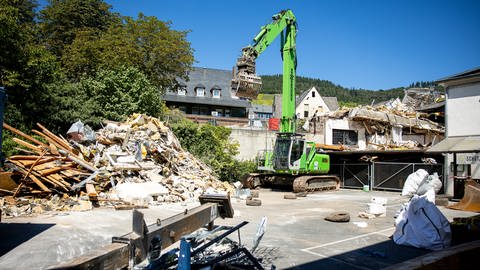 Bagger vor Schutt und Trümmern des eingestürzten Hotels in Kröv