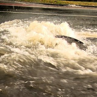 Starkregen - die Wassermassen drücken Gullydeckel hoch.