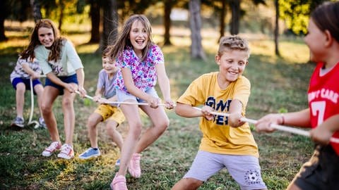 Kinder spielen tauziehen.